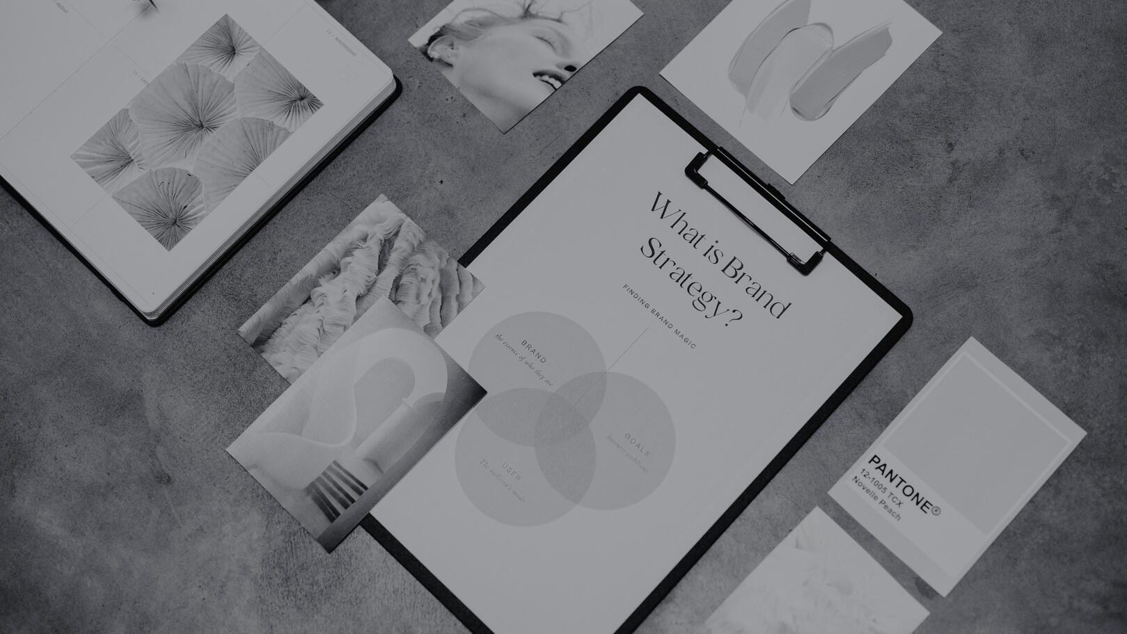 Brand & Content Strategy — Definizione dell'Identità Visiva Moodboard e documenti di brand strategy con mazzetta colori Pantone e schede di identità visiva disposti su un piano da lavoro.